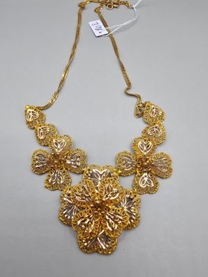 a gold necklace on a white background with a price tag