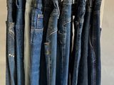 several pairs of blue jeans hanging on a rack in a store