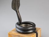 a bronze cobra statue on a marble base