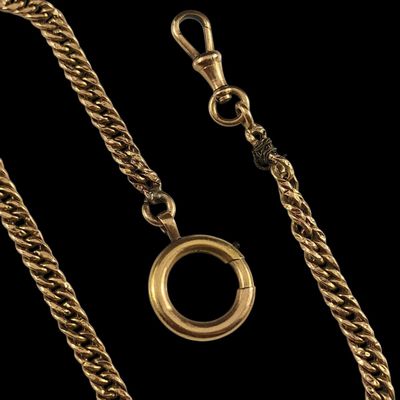 gros plan d'une chaîne en or sur laquelle est fixée une bague