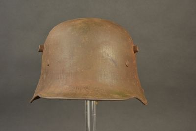 an old helmet on a stand on a gray background