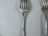 two forks and a spoon sitting on a table