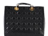 a black quilted handbag with gold hardware on the handles