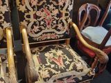 pair of antique chairs in a room with a lot of furniture