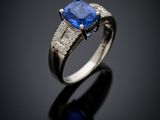 a blue sapphire and diamond ring on a black surface