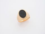 une bague en or avec une pierre noire au centre