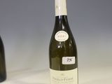 a bottle of wine sitting on a table next to a bottle of wine