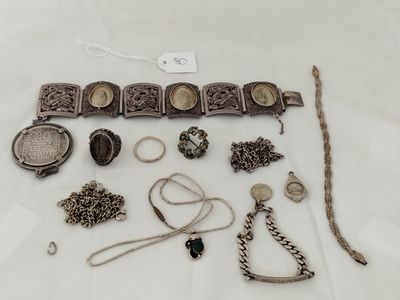 a lot of silver jewelry on a white table