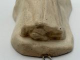 a small statue of a woman laying down on a white surface