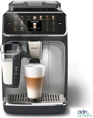 the coffee machine has a glass of milk in it