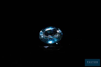 a close up of a blue diamond on a black surface