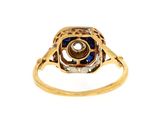 a close up of a gold ring with a sapphire and diamond