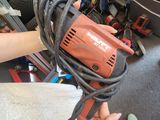 une personne tenant une perceuse filaire à la main