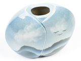 a blue vase that has a bird in the sky on it