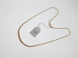 une photo d'un collier en or auquel est accrochée une étiquette