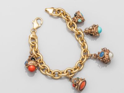 Gros plan sur un bracelet en or orné de breloques