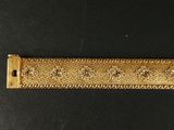 a close up of a gold colored metal ruler on a black surface