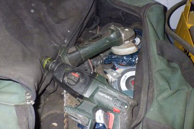 un sac rempli d'outils posé par terre