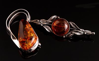 paire de boucles d'oreilles en ambre et argent, ornées de feuilles sur fond noir