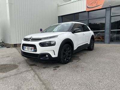 une citrole blanche garée devant un immeuble