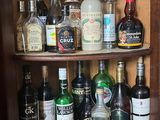 de nombreuses bouteilles d'alcool posées sur une étagère dans un placard