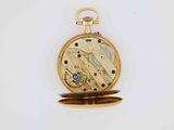 a gold pocket watch with a gold case on a white surface