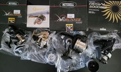 many fishing reels that are sitting on a table