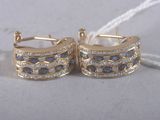 pair of gold tone earrings with blue and white stones on them