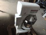 a white mixer sitting on a pallet in a garage