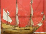 a wooden model of a ship on display in a room