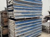 plusieurs piles de bois empilées les unes sur les autres devant un bâtiment