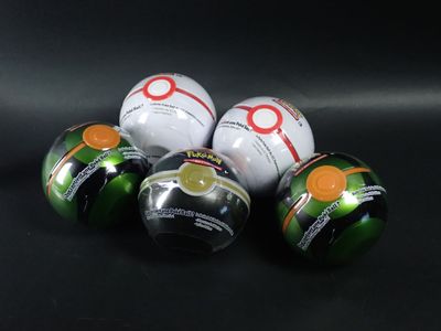 Quatre balles de golf sont alignées sur une surface noire