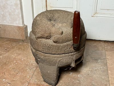 une urne en pierre posée par terre devant une porte
