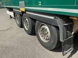 un semi-remorque vert garé sur un parking