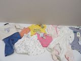 une pile de vêtements de bébé posée sur une table blanche