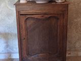 a wooden cabinet with a bunch of dishes on top of it
