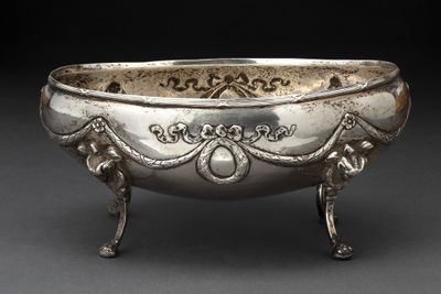 un vieux bol en argent orné de motifs élaborés, posé sur une table