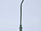 a green lamp post with a light on top of it
