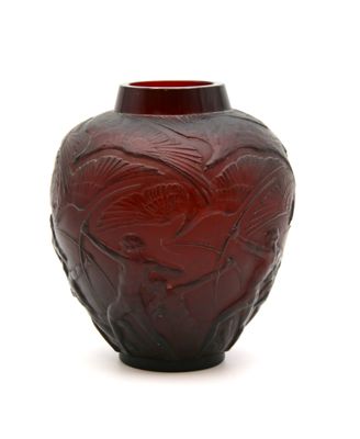un vase rouge orné d'un motif sur un fond blanc