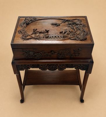une vieille boîte en bois sculptée posée sur une table