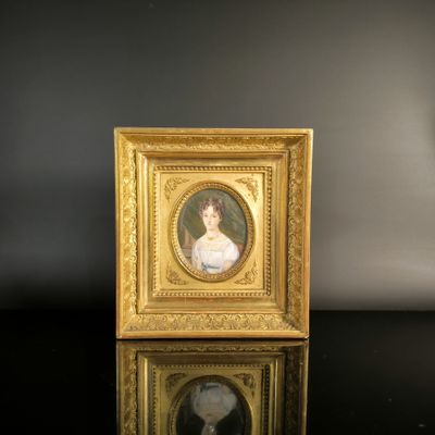 a gold frame with a picture of a woman in a white dress