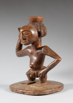 une statue en bois d'un homme avec un chapeau sur la tête