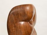 wooden sculpture of a woman ' s torso on a white pedestal