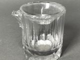 a clear glass cup with a handle on a table
