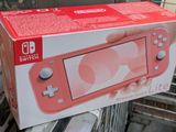 someone is holding a nintendo switch lite box in their hand