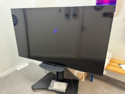 un téléviseur à écran plat posé sur un support dans une pièce