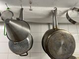 pots and pans hanging on a wall in a kitchen