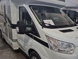 deux camping-cars blancs garés dans un grand entrepôt