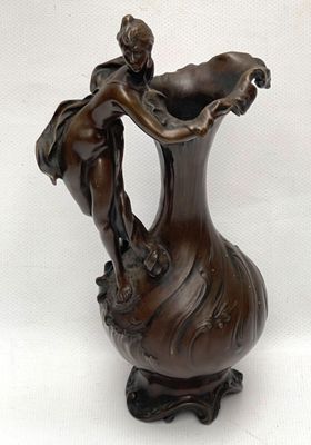a statue of a woman holding a vase on a stand