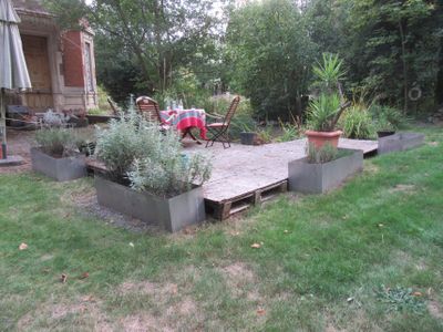une petite terrasse avec une table et des chaises dans le jardin